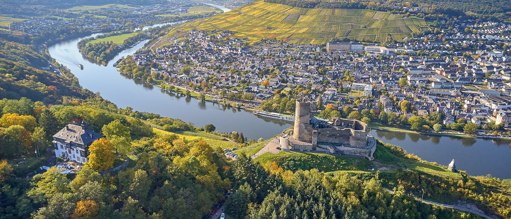 Bild aus der Vogelperspektive auf die Burg Landshut und das Moseltal Drohnenbild der Burg Landshut, die auf einem Berg hoch über der Mosel thront. Im Hintergrund die Mosel und der Stadtteil Kues.
