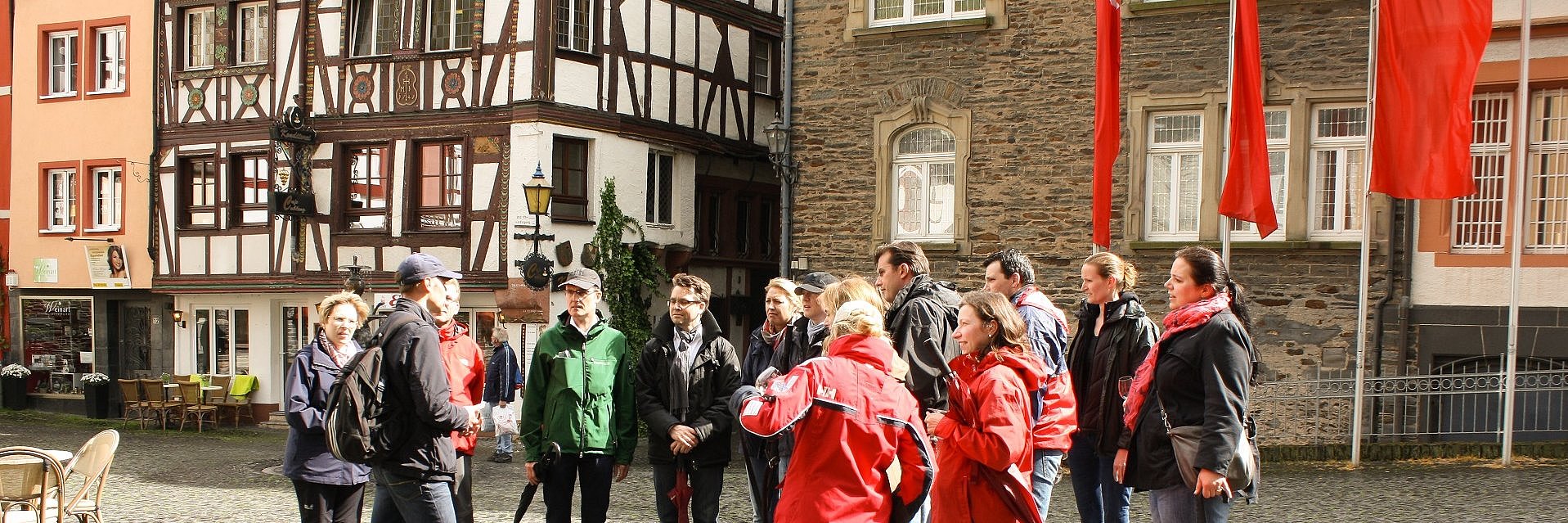 Spannende Gästeführung durch die Altstadt von Bernkastel-Kues Ansicht auf eine Gruppe von Menschen während einer Gästeführung auf dem historischen Karlsbader Platz in Bernkastel-Kues.
