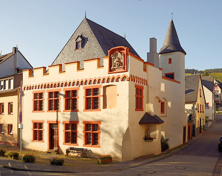 Das weiße Cusanus-Geburtshaus mit seinen roten Fensterläden.